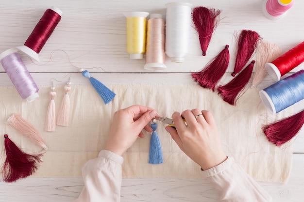 dłonie trzymające igłę nad materiałem